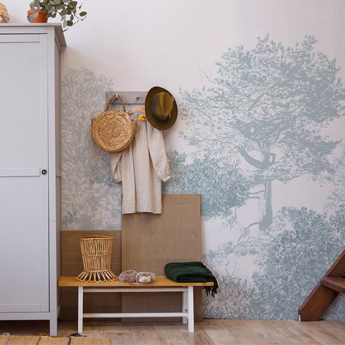Hua Trees Blue Mural Wallpaper behind table and chair Sian Zeng