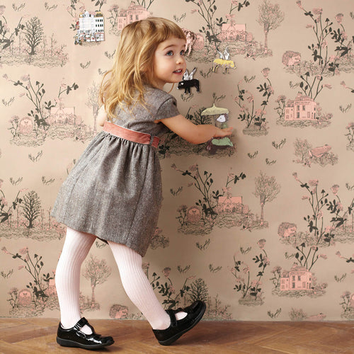 brown and pink earthy enchanted forest children's magnetic wallpaper with little girl playing with magnets on wall surface