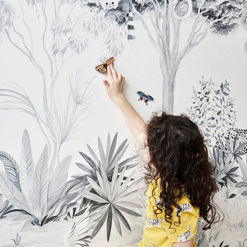 monochrome grey jungle animals magnetic wallpaper mural on wall with girl playing with magnets on surface