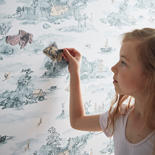 blue and orange mountain bears children's magnetic wallpaper with little girl playing with magnets on wall surface