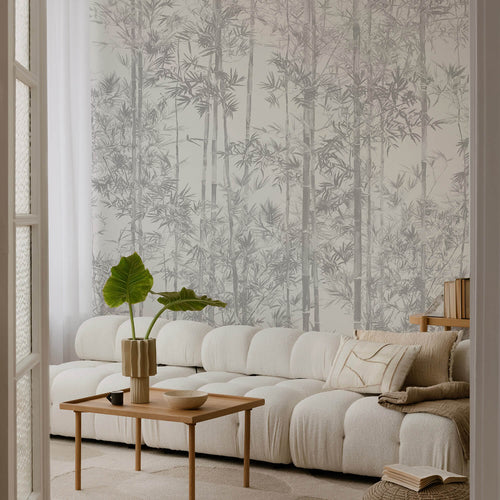 Living room with white sectional sofa, wooden coffee table, and decorative elements against a wall with bamboo nature-themed wallpaper.