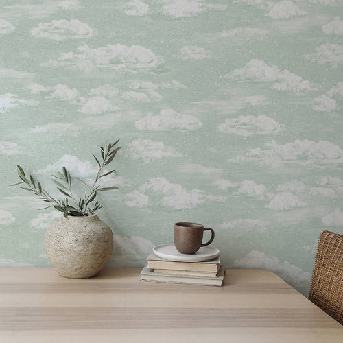Dining table propped against wall featuring green clouds wallpaper