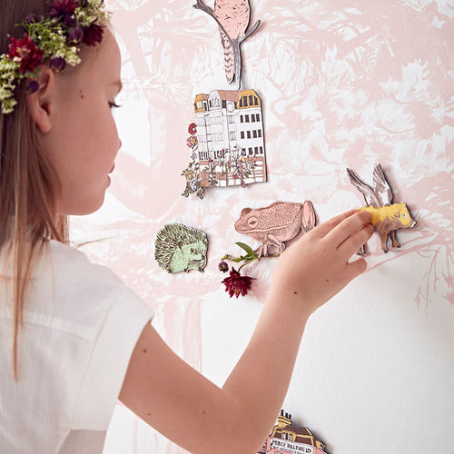 Pink Trees Forest Magnetic Wallpaper Mural avec une petite fille jouant sur la surface du mur avec des aimants